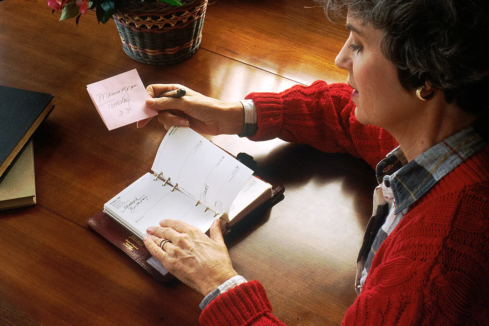 A woman paging through a well-kept appointment book at her desk